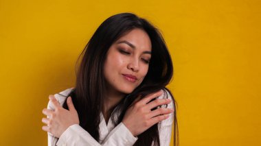 20 'li yaşlarının ortasında genç bir kadın kameraya poz veriyor.