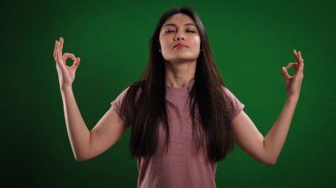 Genç bir kadın tarafsız bir geçmişe karşı meditasyon yapıyor.