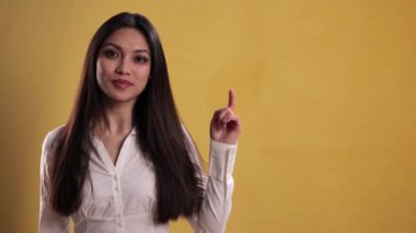 Genç ve güzel bir kadın bir şeye işaret ediyor.