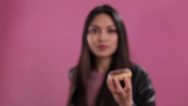 갓 구운 도넛을 들고 있는 예쁜 아가씨 — 비디오