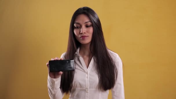 Joven bonita mujer muestra algo en su teléfono — Vídeo de stock