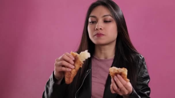 Young woman eats a freshly baked French croissant — Stock Video