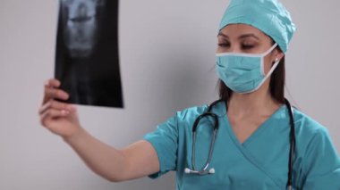 Kadın doktor röntgenlere bakar.