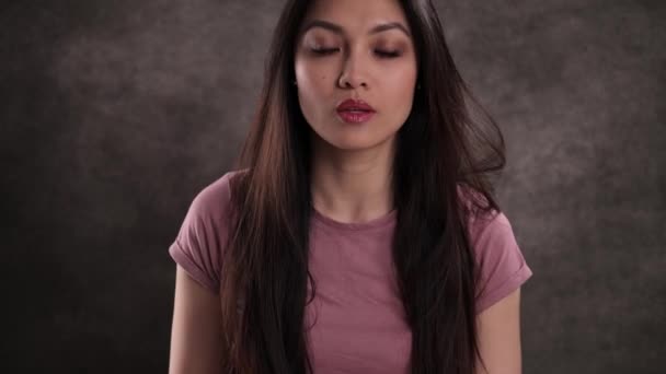 Portret van een jonge mooie vrouw tegen een neutrale achtergrond — Stockvideo