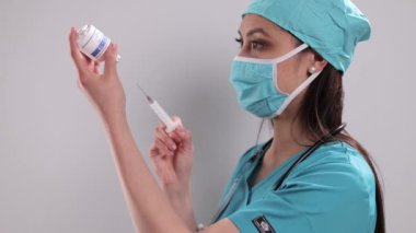 Kadın doktor şırınga hazırlıyor.