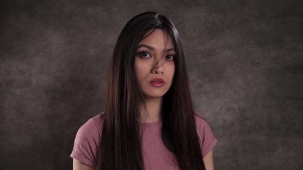 Portret van een jonge mooie vrouw tegen een neutrale achtergrond — Stockvideo