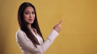 Genç ve güzel bir kadın bir şeye işaret ediyor.