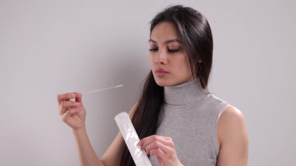 Genç bir kadın Covid-19 antijen testi uygular. — Stok video