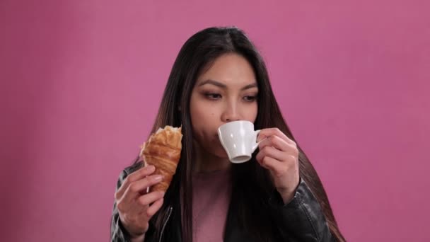 Young woman eats a freshly baked French croissant — Stock Video