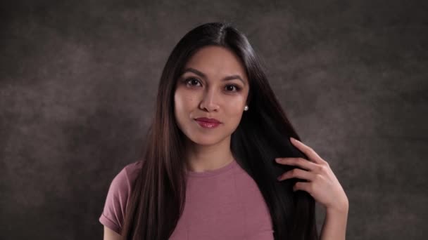 Porträt einer jungen schönen Frau vor neutralem Hintergrund — Stockvideo
