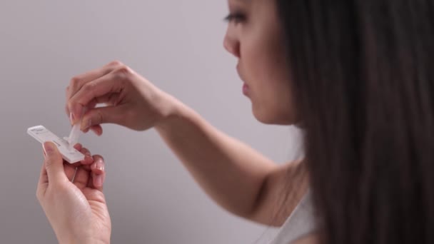 젊은 여성은 Covid-19 antigen self-test 를 수행 한다 — 비디오