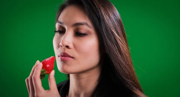 Молода красива жінка кусає полуницю — стокове фото