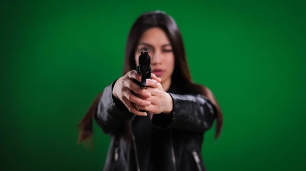 Fiatal női ügynök pisztollyal a kezében a kamerába lő. — Stock Fotó