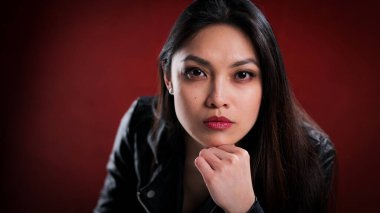 Kırmızı kadifenin önünde seksi Asyalı kadın.