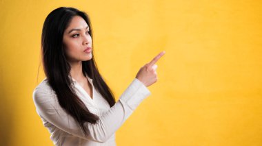 Genç ve güzel bir kadın bir şeye işaret ediyor.
