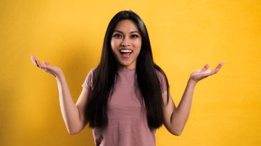 Sarı arka planda genç ve güzel bir kadının yakın çekimi.