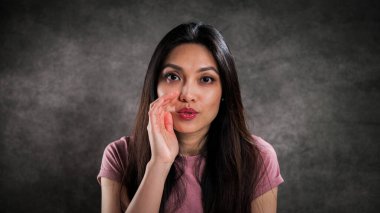 Genç bir kadın kameraya bir şeyler fısıldıyor.