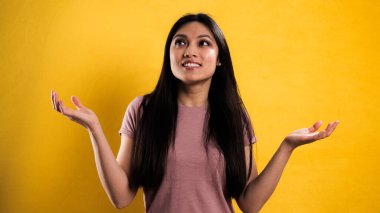 Sarı arka planda genç ve güzel bir kadının yakın çekimi.