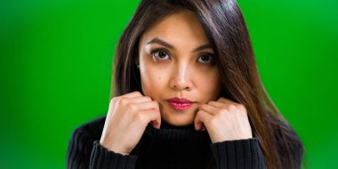 Stüdyoda kameraya poz veren genç ve güzel bir kadın.