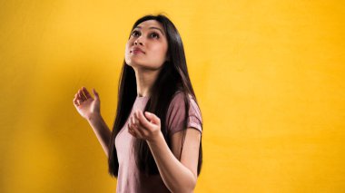 Sarı arka planda genç ve güzel bir kadının yakın çekimi.