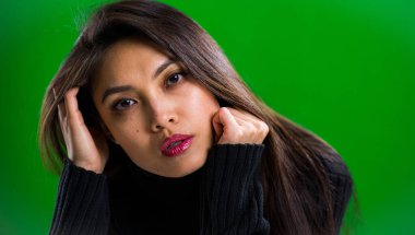 Stüdyoda kameraya poz veren genç ve güzel bir kadın.