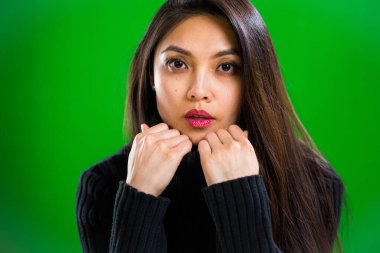 Stüdyoda kameraya poz veren genç ve güzel bir kadın.