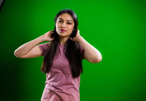 Nuori kaunis nainen poseeraa kameralle studiossa — kuvapankkivalokuva