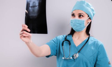 Hastanedeki kadın doktor röntgenlere bakıyor.