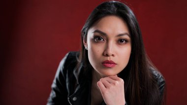 Kırmızı arka planda kendine güvenen genç bir kadın.