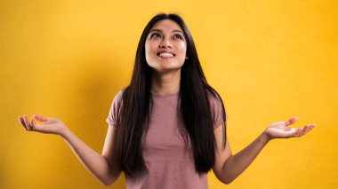 Sarı arka planda genç ve güzel bir kadının yakın çekimi.