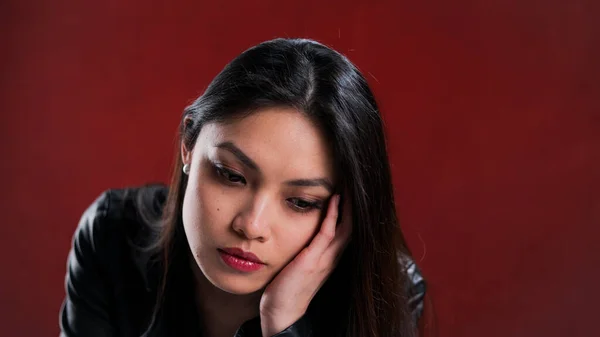 Junge nachdenkliche Frau vor rotem Hintergrund — Stockfoto