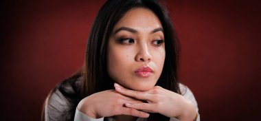 Genç bir kadının düşünceli yüz ifadesi.