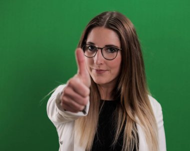 Genç ve güzel bir kadın baş parmak hareketi yapıyor.