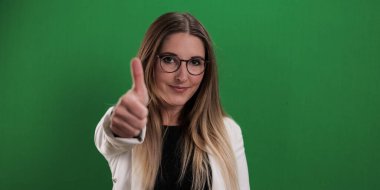 Genç ve güzel bir kadın baş parmak hareketi yapıyor.