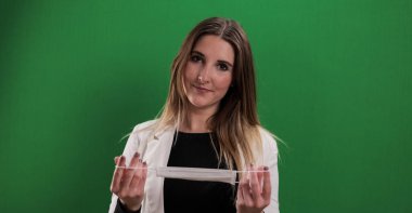 Genç bir kadın tıbbi maske takıyor.