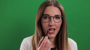 Genç ve güzel kadın dudaklarını yapıyor.