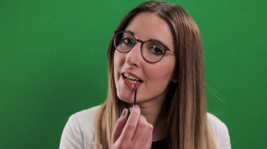 Genç ve güzel kadın dudaklarını yapıyor.