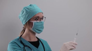 Kadın doktor Corona aşısıyla bir şırınga hazırlıyor.