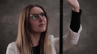 Genç ve güzel bir kadın film şeridine bakıyor.