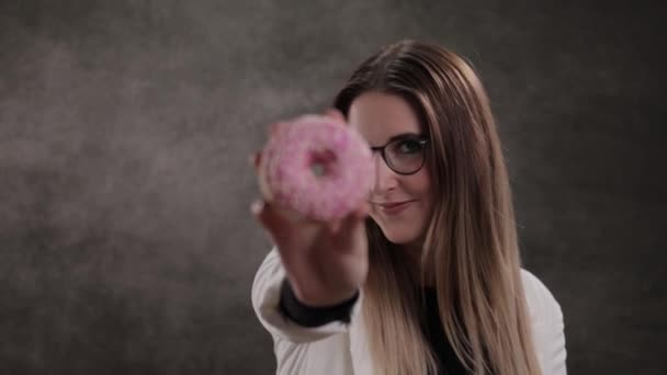 Junge Frau isst einen frisch gebackenen Donut — Stockvideo