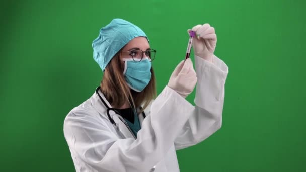 Женщина-врач осматривает образец крови — стоковое видео