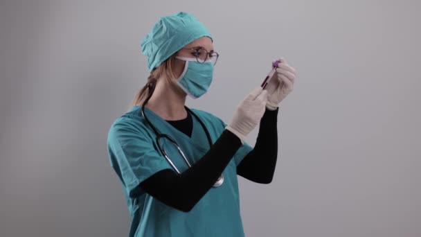 Женщина-врач проверяет образец крови на вирус Короны — стоковое видео