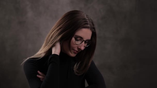 Close-up of a young attractive woman against dark grey background — Stock Video