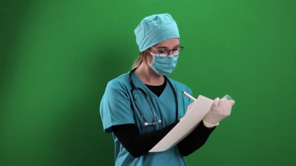 Vrouwelijke arts neemt notities in een bestand — Stockvideo
