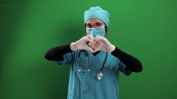 Female doctor forms the shape of a heart — Stock Video