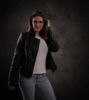 Koyu gri arka planda genç ve çekici bir kadının yakın çekimi.