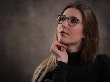 Düşünceli yüz ifadesi olan genç bir kadın.