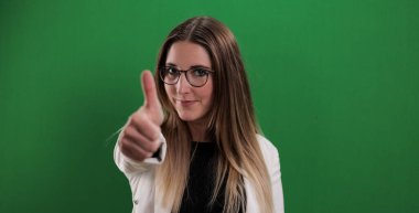 Genç ve güzel bir kadın baş parmak hareketi yapıyor.