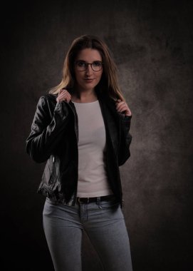 Koyu gri arka planda genç ve çekici bir kadının yakın çekimi.