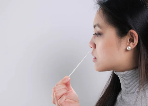 若い女性はコロナ検査のために鼻からサンプルを取ります — ストック写真